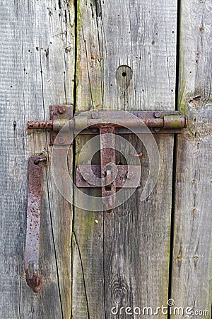 Rusty rural handmade lock on aged wooden village barn door Stock Photo