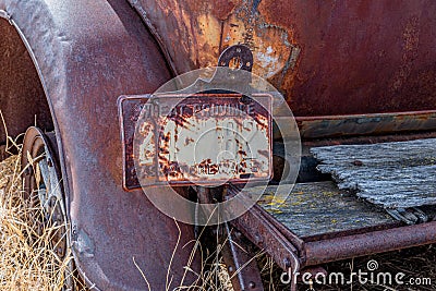 An rusty Saskatchewan license plate attached to an abandoned classic car Stock Photo