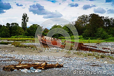 Rusty ship stranded aground on the beach with pebbles in the Black Sea Stock Photo