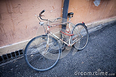 Rusty vintage bicycle near the concrete wall Stock Photo