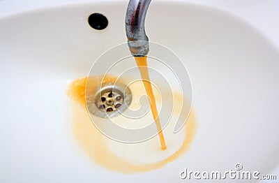 Rusty water running from a faucet Stock Photo