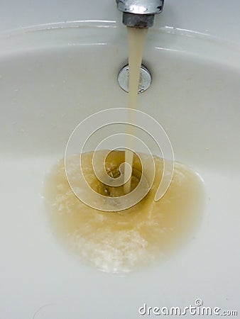 Rusty water running from a faucet Stock Photo