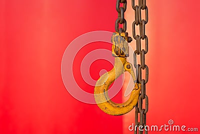 Rusty Yellow Hook and chains with red background Stock Photo