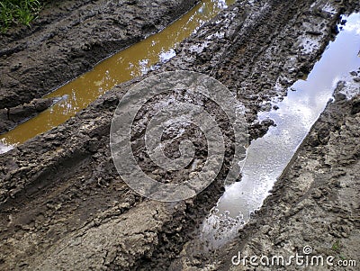 Rut-filled dirt road with puddles Stock Photo