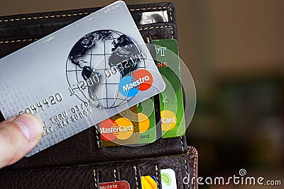 Ryazan, Russia - February 27, 2018: Credit card of Maestro brand over the leather wallet and number of cards. Editorial Stock Photo