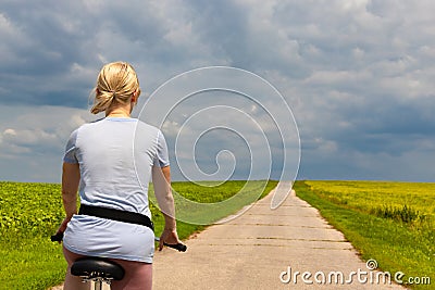 Ryazan, Russia - July 18, 2023: girl riding a bike on a country road Editorial Stock Photo