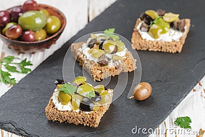 Rye bread toast canape with kalamata, black and green olives, feta chees Stock Photo