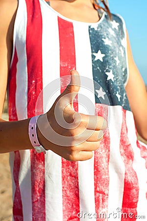 It`s alright! Young girl in american shirt showing thumb up. Stock Photo