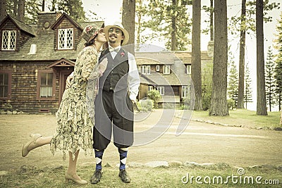 1920s Dressed Romantic Couple in Front of Old Cabin Stock Photo