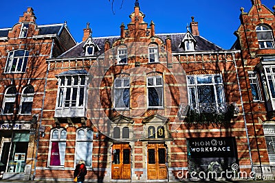 Front view typical dutch red brick gabled houses with shadows of bare trees against blue winter sky Editorial Stock Photo