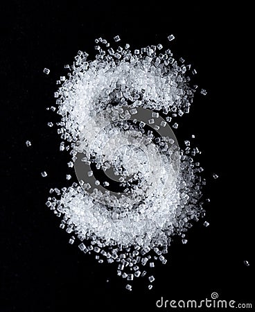 S letter made with sugar, top view macro shot. Stock Photo