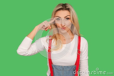 That`s silly, insane crazy plan. Portrait of amazed displeased adult woman in denim overalls showing stupid gesture Stock Photo
