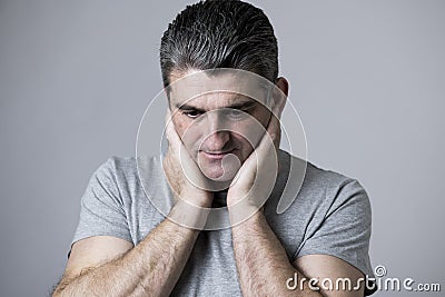 40s to 50s sad and worried man looking frustrated and thoughtful in worried and pensive face expression isolated on grey Stock Photo