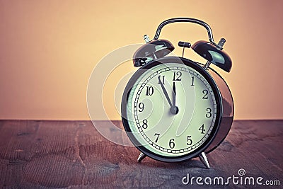 It`s twelve o`clock already, time to wake up for lunch, vintage old black metallic alarm clock Stock Photo