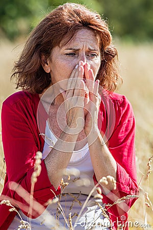 50s woman sneezing for rhinitis,allergies or hay fever Stock Photo