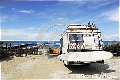 Sabaudia, Lazio, Italy - April 12, 2018: Rear of vintage camper parked on the beach seaside with a surfboard on back - Leisure Editorial Stock Photo