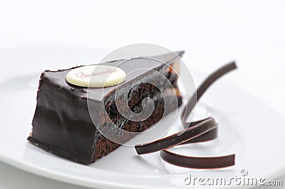 Sacher torte, chocolate tart with swirls on white plate, sweet dessert, patisserie, photography for shop Stock Photo