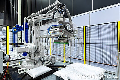 Sack gripper on industrial robot arm in production line manufacturer factory. Stock Photo