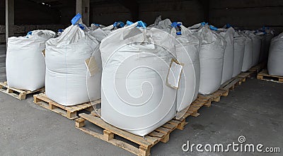 Sacks of flour and grain are stacked in neat rows in the warehouse of the processing factory. Stock Photo