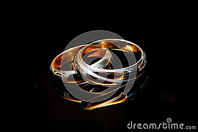 Sacrament: Matrimony. Wedding rings on a black background with reflection, close-up Stock Photo