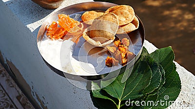 Sacred food on a leaf for the crow bird to eat. Food placed on a green leaf during a Hindu Ritual in the Stock Photo