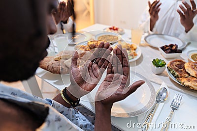 In the sacred month of Ramadan, a diverse Muslim family comes together in spiritual unity, fervently praying to God Stock Photo