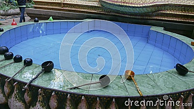 The sacred pond with and many water bowl placed on the edge of the pond in Kham Chanot forest according to the belief of Thai peop Stock Photo