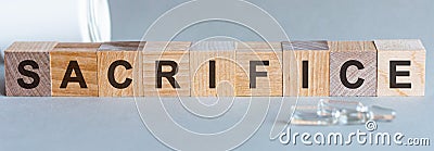 The word SACRIFICE written in wooden letters on a grey background Stock Photo