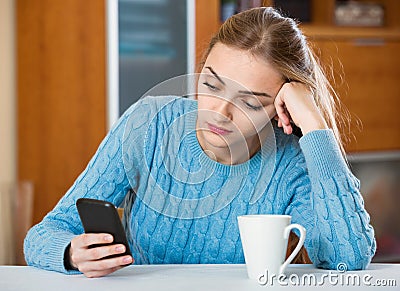 Sad adult girl waiting for important call Stock Photo