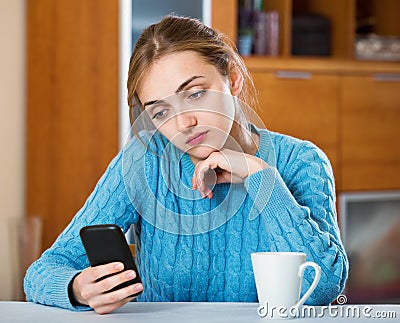 Sad adult girl waiting for important call Stock Photo