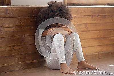 Upset biracial preschooler girl cry sitting on floor Stock Photo