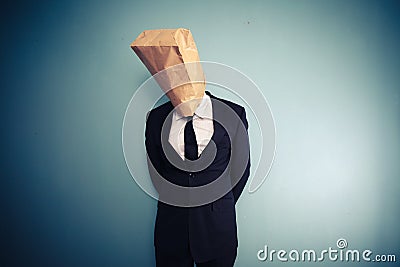 Sad and ashamed businessman with bag over head Stock Photo