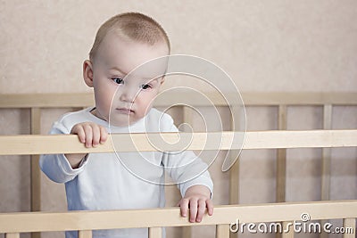 Sad baby is in cot Stock Photo