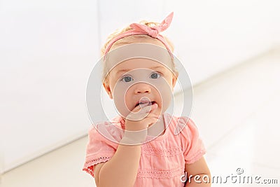 Sad baby girl gnaw her hand. Stock Photo