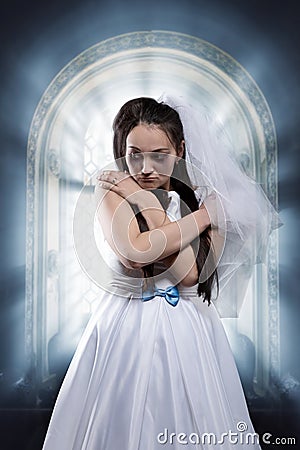 Sad bride, window ful of sunshine on background Stock Photo