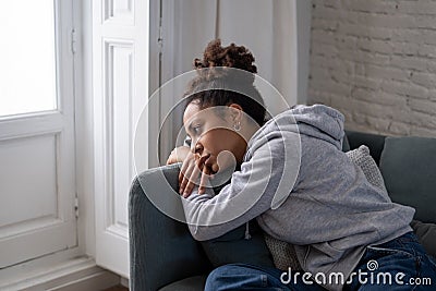 Sad black woman suffering from depression symptoms feeling distressed alone at home Stock Photo