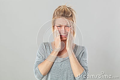 Sad blond woman crying expressing despair and distraught Stock Photo