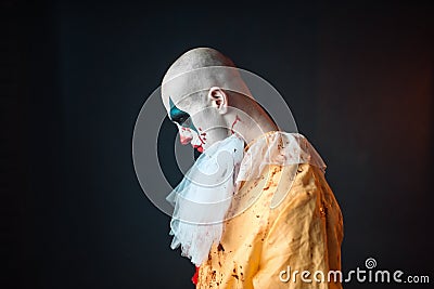 Sad bloody clown with makeup in carnival costume Stock Photo