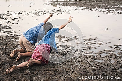 Sad boy and girl praying for the rain on lake Stock Photo