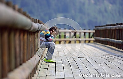 Sad boy sitting alone Stock Photo