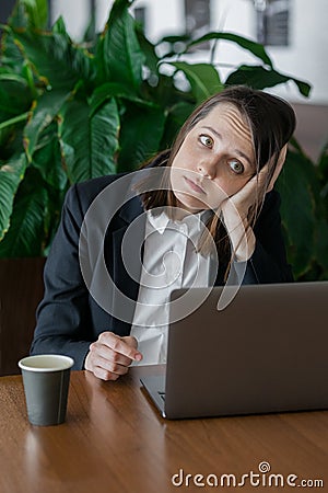 sad business woman with dark short hair working at the computer and bored Stock Photo