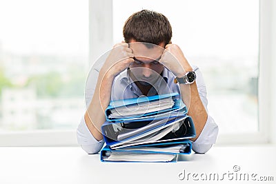 Sad businessman with stack of folders at office Stock Photo