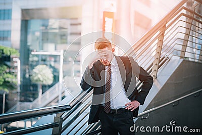 Sad businessman stressed and worried look down at outside office. Stress and worry concept Stock Photo