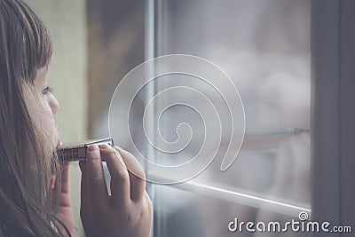 Sad girl playing harmonica Stock Photo