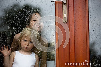 Sad child behind the window on rainy day Stock Photo