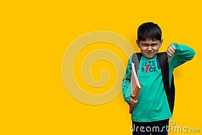 Sad child boy with books in hand and bag on shoulders, hate study concept copy space Stock Photo
