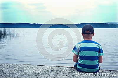 Sad child sitting alone Stock Photo