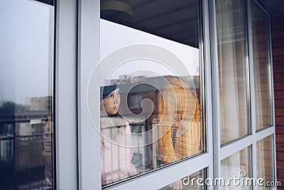 Sad children are looking out the window. Time of the pandemic. Stock Photo