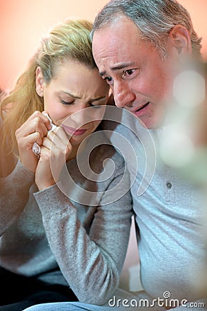 sad couple comforting each other at home Stock Photo