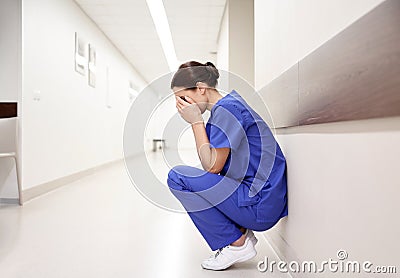 Sad or crying female nurse at hospital corridor Stock Photo